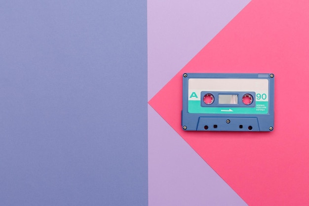 Blaue Audiokassette auf einem rosa und lila Hintergrund