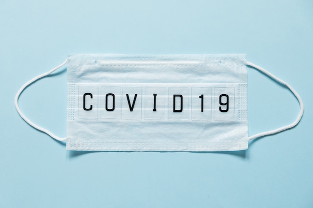 Blaue chirurgische Maske mit darauf geschriebenem Coronavirus-Text. 2019-nCoV-Virusinfektion in der Stadt Wuhan. Covid-19 (SARS-CoV-2) verbreitete sich auf der ganzen Welt. Auswirkungen des Pandemievirus.
