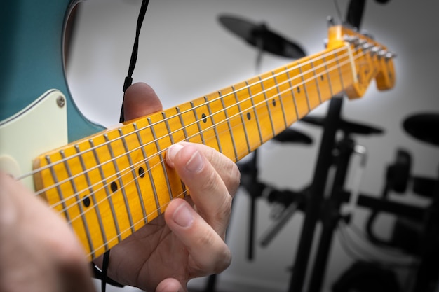 Foto blaue e-gitarre im musikalischen solo, die detailliert zeigt, wie die saite angehoben wird