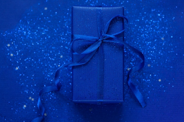 Blaue Geschenkbox mit blauem Bogen auf blauem Hintergrund