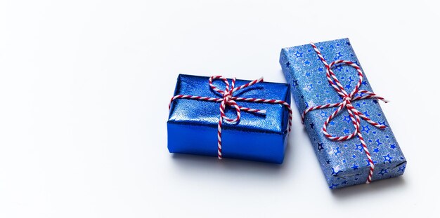 Blaue Geschenkbox mit roten Bändern isoliert auf weißem Hintergrund