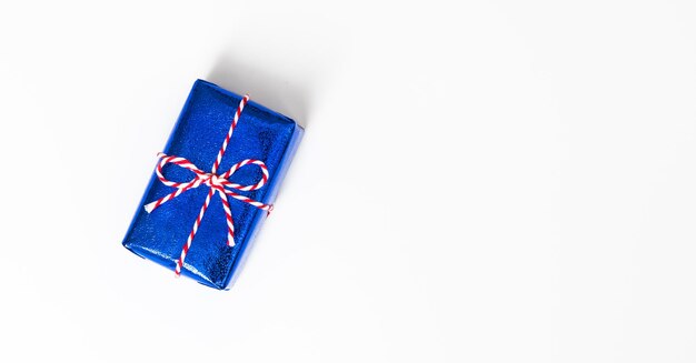 Blaue Geschenkbox mit roten Bändern isoliert auf weißem Hintergrund