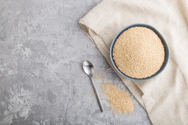 Blaue Keramikschale mit rohen weißen Quinoa-Samen