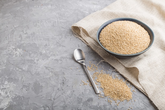 Blaue Keramikschale mit rohen weißen Quinoa-Samen