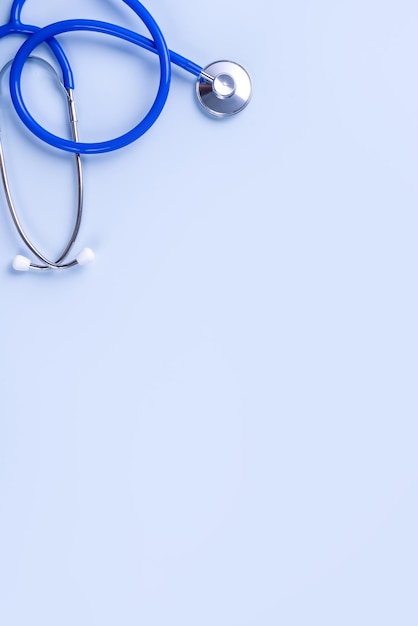 Blaue Maske medizinische Ausrüstung mit Stethoskop-Konzept der Weltkrankheit Pandemie-Infektion und Prävention Draufsicht flach über dem Kopf liegend Design