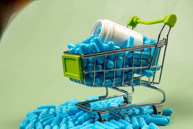 Blaue Medikamentenkapsel im Miniatur-Einkaufswagen