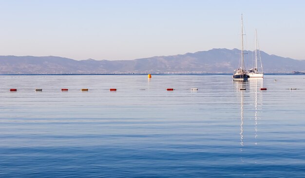 Blaue Meerboote Berge und Inseln an den Sommerferien der Ägäis und Küstennaturkonzept