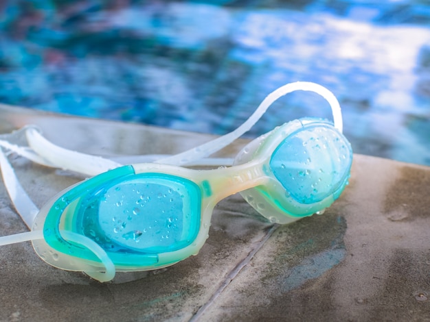 Blaue moderne Schwimmbrille neben dem Pool.