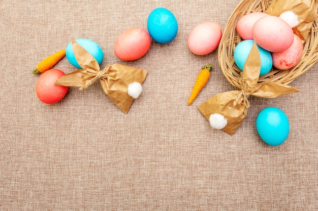 Blaue, rote und rosa Eier für Ostern mit Papierhäschen