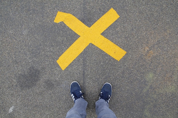 Foto blaue schuhe, die vor einem kreuz stehen