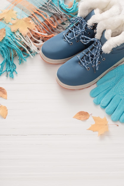 Blaue Schuhe und Handschuhe auf weißem hölzernem Hintergrund