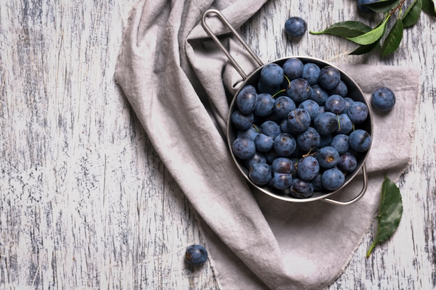 Blaue Schwarzdornbeeren in der Metallschale auf einem Tisch