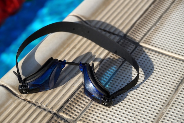 Blaue Schwimmbrille zum Schwimmen an einer Seite des Schwimmbeckens