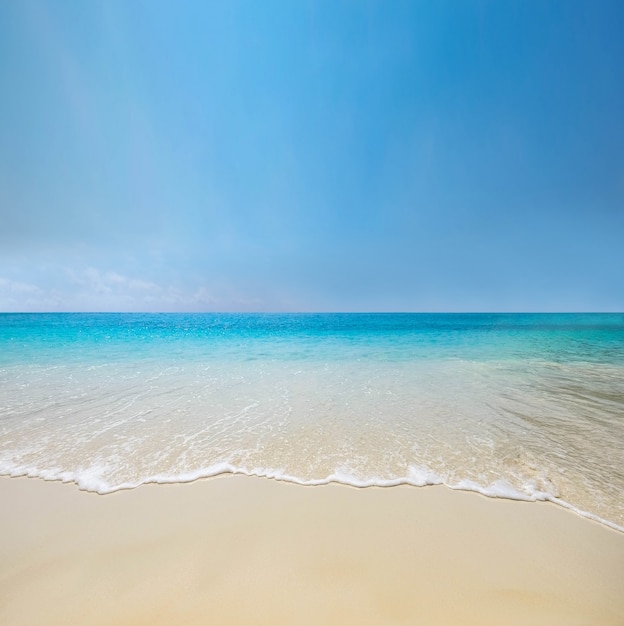 Blaue Seewelle auf Sandstrand