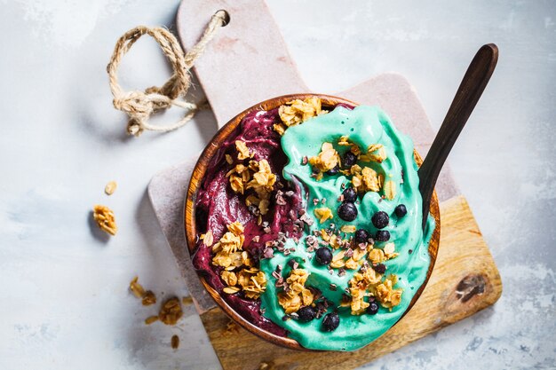 Foto blaue spirulina- und beeren smoothieschüssel auf grauem hintergrund