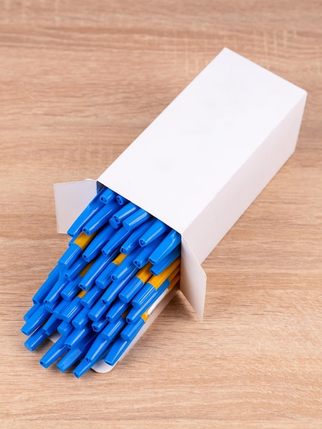 Blaue Stifte in einer weißen Box auf dem Bürotisch. Satz Stifte