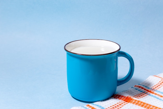 Blaue Tasse Milch auf hellblau