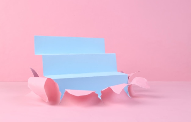 Blaue Treppe durch zerrissenes rosa Pastellpapier Minimalismus Kreativer Hintergrund