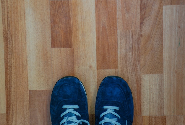 Blaue Turnschuhe auf Holzboden