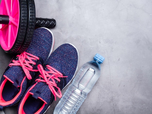 Blaue Turnschuhe Flasche Wassersportrad auf Steinhintergrund Konzept des gesunden Lebensstils Alltagstraining und Willenskraft