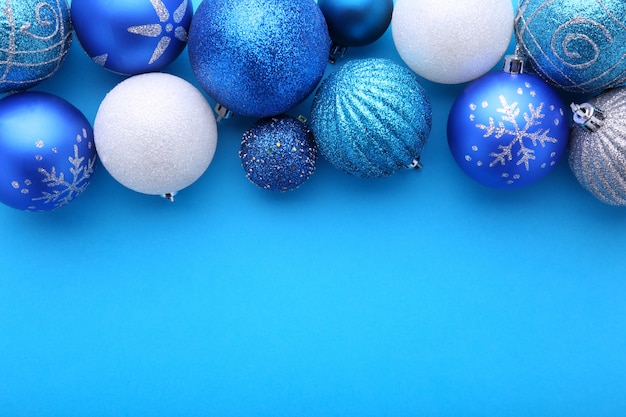 Blaue und silberne Weihnachtsbälle auf einem blauen Hintergrund