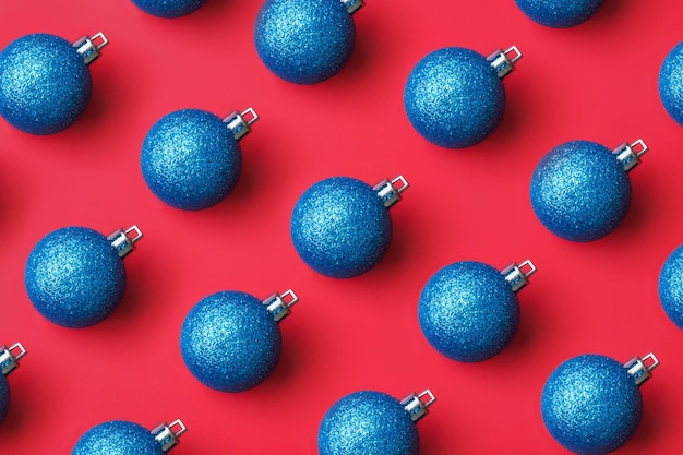 Blaue Weihnachtskugel Flittermuster minimal flatlay auf rotem Hintergrund Draufsicht