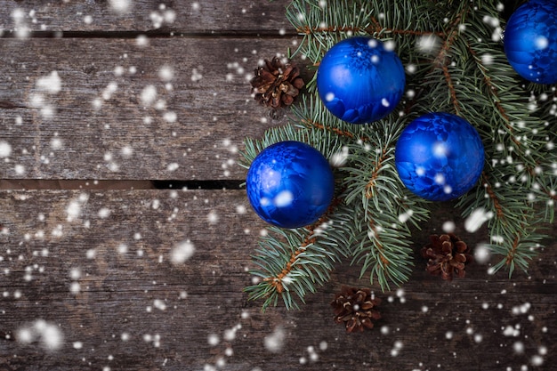 Blaue Weihnachtskugeln und Tannenzweig. Tiefenschärfe, Schneeeffekt