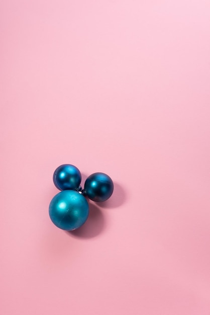 Blaue Weihnachtsspielzeugkugeln auf rosa Hintergrund Minimalistischer Hintergrund