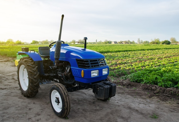 Blauer Ackerschlepper steht auf Feldanwendung von Landmaschinen bei der Ernte harvest