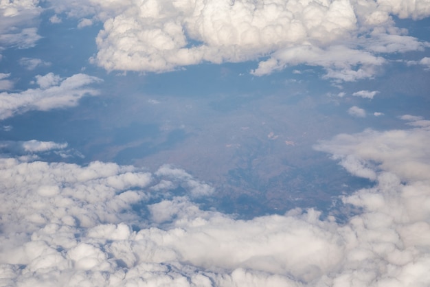 Blauer bewölkter Himmel, Ansicht vom Flugzeugfenster. Luftbild von Wolkengebilde