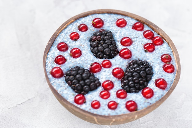 Blauer chia Samenpudding mit Brombeeren und Beeren der roten Johannisbeere in einer Schüssel