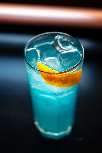 Blauer Cocktail im Highball mit Eis und Orangenschale