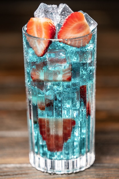 Blauer Cocktail mit Eis und Erdbeeren