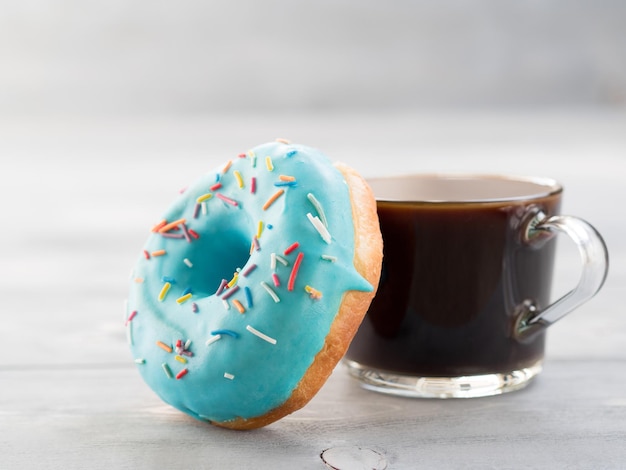 Blauer Donut und Kaffee auf grauem hölzern Hintergrund Kopierraum