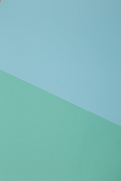 Blauer, grüner Hintergrund, farbiges Papier unterteilt sich geometrisch in Zonen