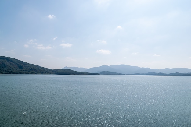 Blauer Himmel, grüne Berge und Bäume umgeben den See