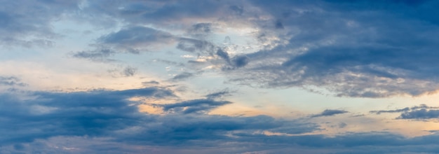 Blauer Himmel mit dunklen Wolken bei Sonnenuntergang