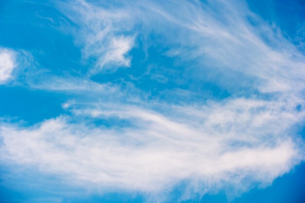 Blauer Himmel mit flaumigem Wolkenhintergrund.