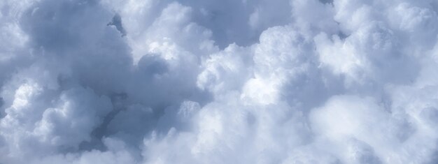 Blauer Himmel mit weißen Wolken bei sonnigem Wetter. Flauschige Atmosphäre mit bewölktem Himmel aus dem Flugzeugfenster.