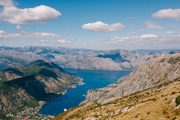 Blauer Himmel mit weißen Wolken über dem azurblauen Wasser der Bucht von Kotor Mount lovcen