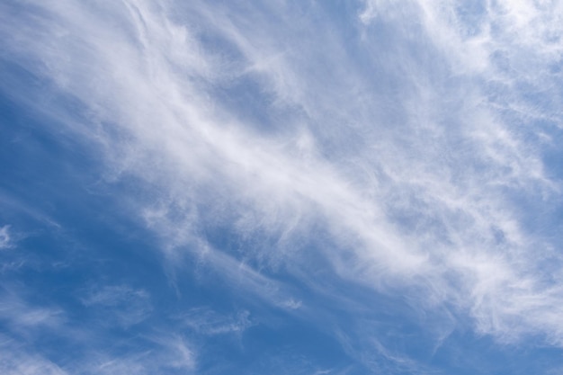 Blauer Himmel mit windigen Wolken Natürliche Hintergrundfoto-Textur, die an einem sonnigen Tag aufgenommen wurde Cirrus-Typ von Wolken Ungewöhnliche weiße gestreifte wellenförmige Wolken an einem hellen blauen Himmel Himmlischer Hintergrund für Ihre Fotos