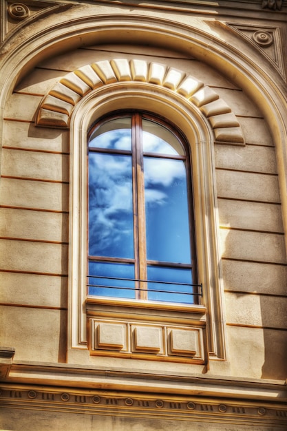 Blauer Himmel mit Wolken, die sich in einem künstlerischen Fenster widerspiegeln