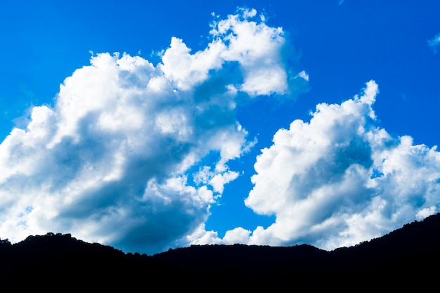 blauer Himmel mit Wolken und Berg