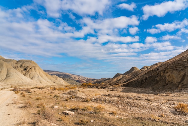 Blauer Himmel mit Wolken und Felsen in der Hochgebirgswüste