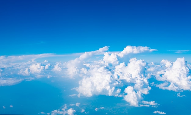 Blauer Himmel mit Wolken und Sonne auf Flugzeugansicht.