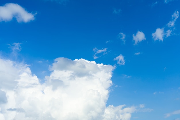 Blauer Himmelhintergrund mit weißem flauschigem Wolkenbild