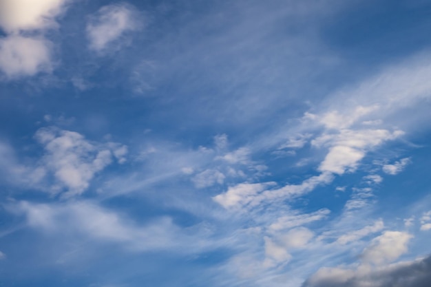 Blauer Himmelshintergrund mit großer, winziger, gestreifter Stratus-Zirruswolke vor Sturm