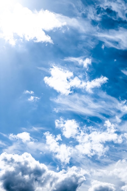 Blauer Himmelshintergrund, weiße Wolken und helles Sonnenlicht