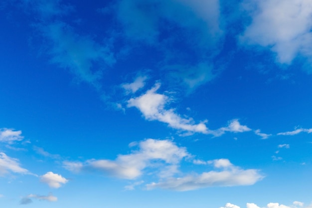 Blauer Hintergrund mit Wolken an einem sonnigen Tag.