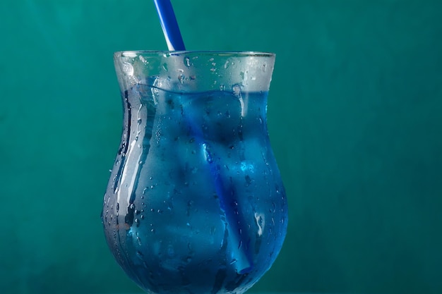 Foto blauer kalter cocktail im glas mit eis und klaren tautropfen auf glas